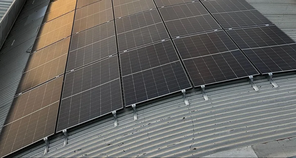 Moduli fotovoltaici fissati con staffe su una copertura industriale in lamiera